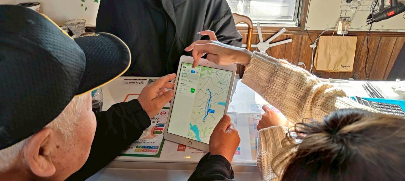 タブレットの地図を一緒に見るお客様とスタッフ