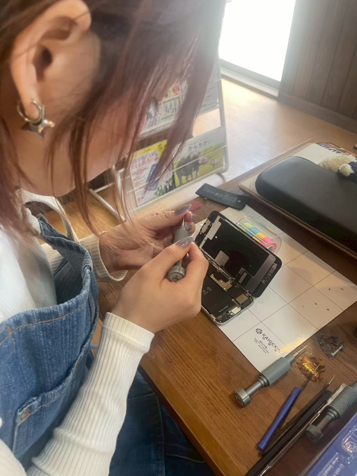 iPhoneの内部を丁寧に分解するスタッフの手元